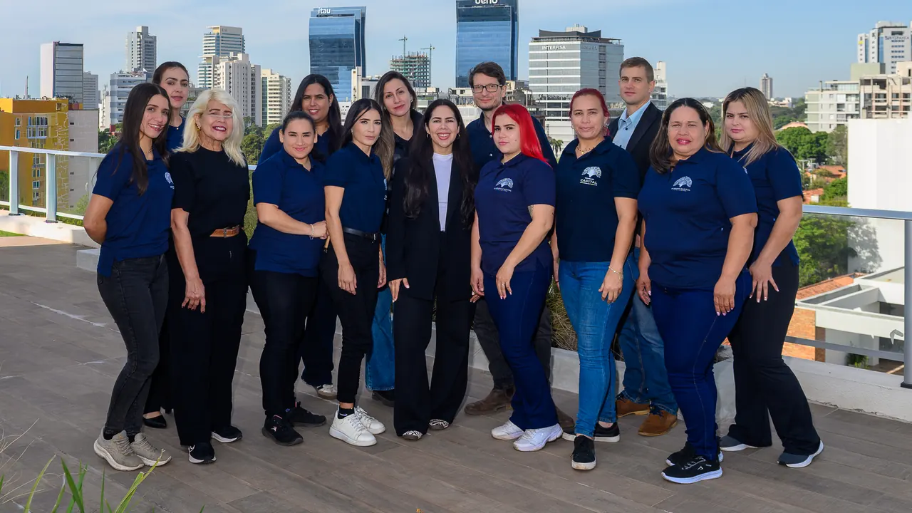 El equipo de Guaraní Capital, catorce personas, en una terraza con el skyline de Asunción de fondo